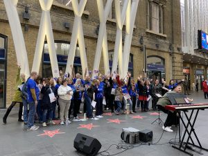 A large choir at Kings Cross station